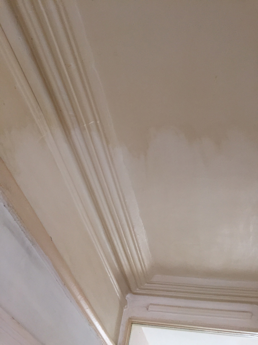 Ceiling with nicotine stains being cleaned before painting
