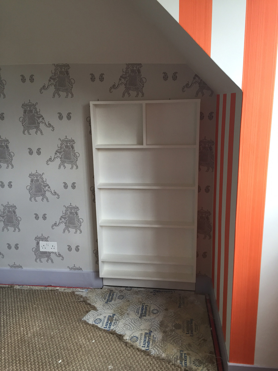 Remodelling project showing new wallpaper, painting and shelves which double as a hidden door to play room